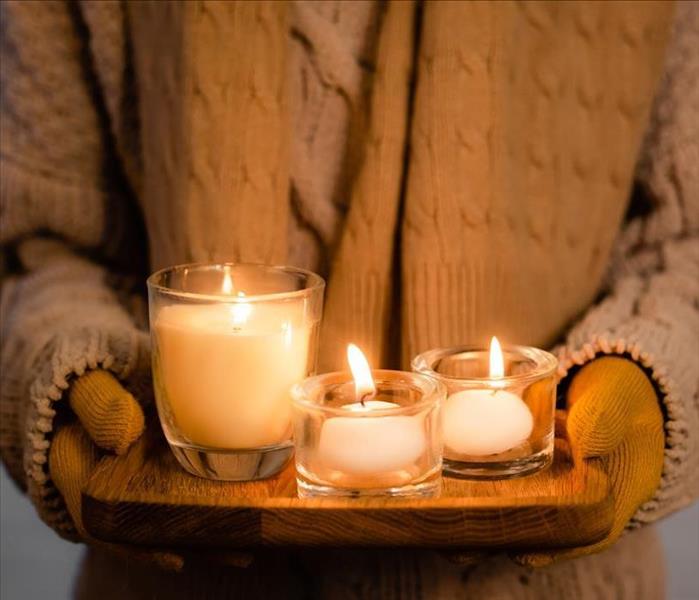 Image of a person holding 3 candles